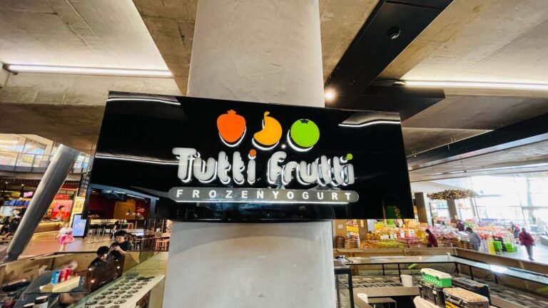 Tutti Frutti black illuminated column sign in a shopping centre