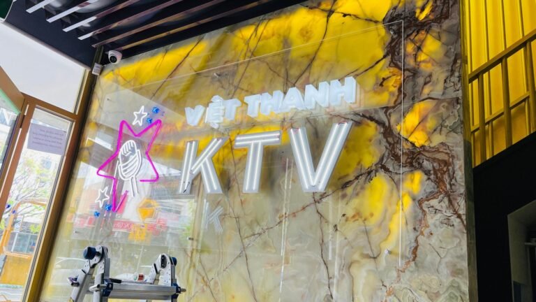 Viet Thanh KTV illuminated logo sign on a marble feature wall