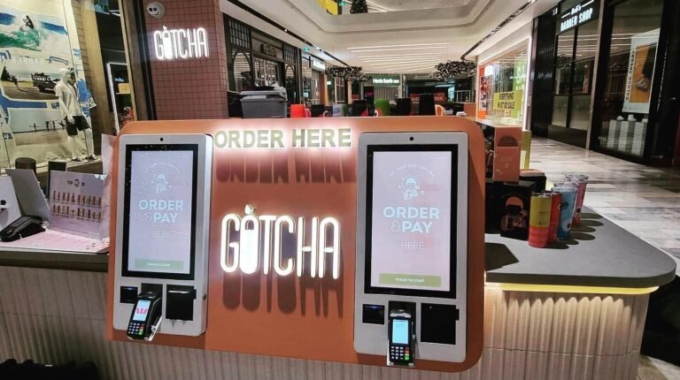 Gotcha kiosk with illuminated logo and self-order screens