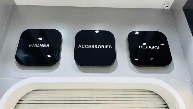 Black acrylic Phones, Accessories and Repairs signs in a phone store