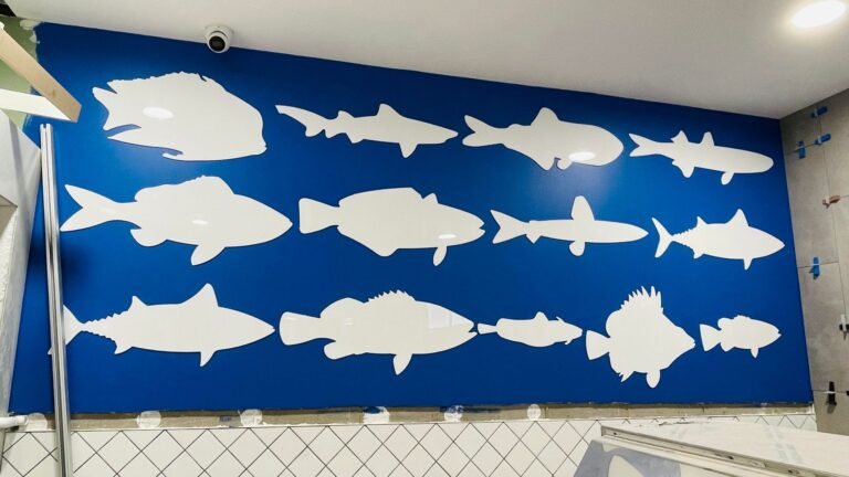 White fish silhouette wall graphics on a navy blue feature wall