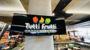 Tutti Frutti illuminated sign wrapped around a shopping centre column