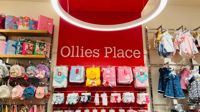 Ollies Place in-store sign on a red feature wall in a children's clothing store