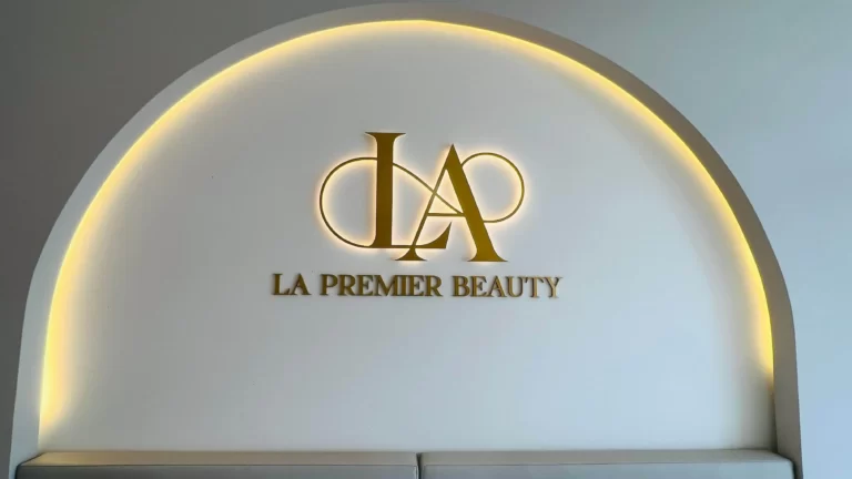 LA Premier Beauty gold logo inside an illuminated arch feature wall