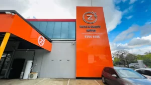 Orange cladding facade and tower sign for Z Nails & Beauty Supply