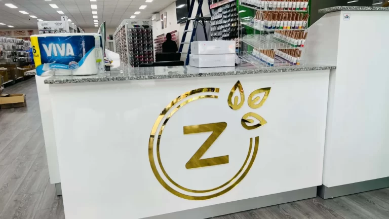 White reception counter with a gold Z logo sign