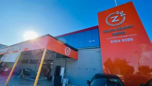 Orange building fascia and tower sign for Z Nails & Beauty Supply