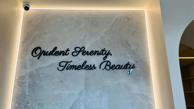 Script lettering "Opulent Serenity, Timeless Beauty" on a marble feature wall with LED strip lighting