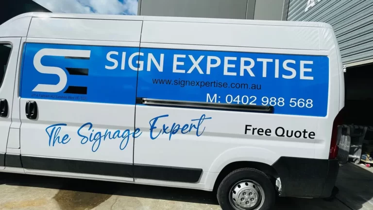 Side of a white van with Sign Expertise logo and phone number graphics